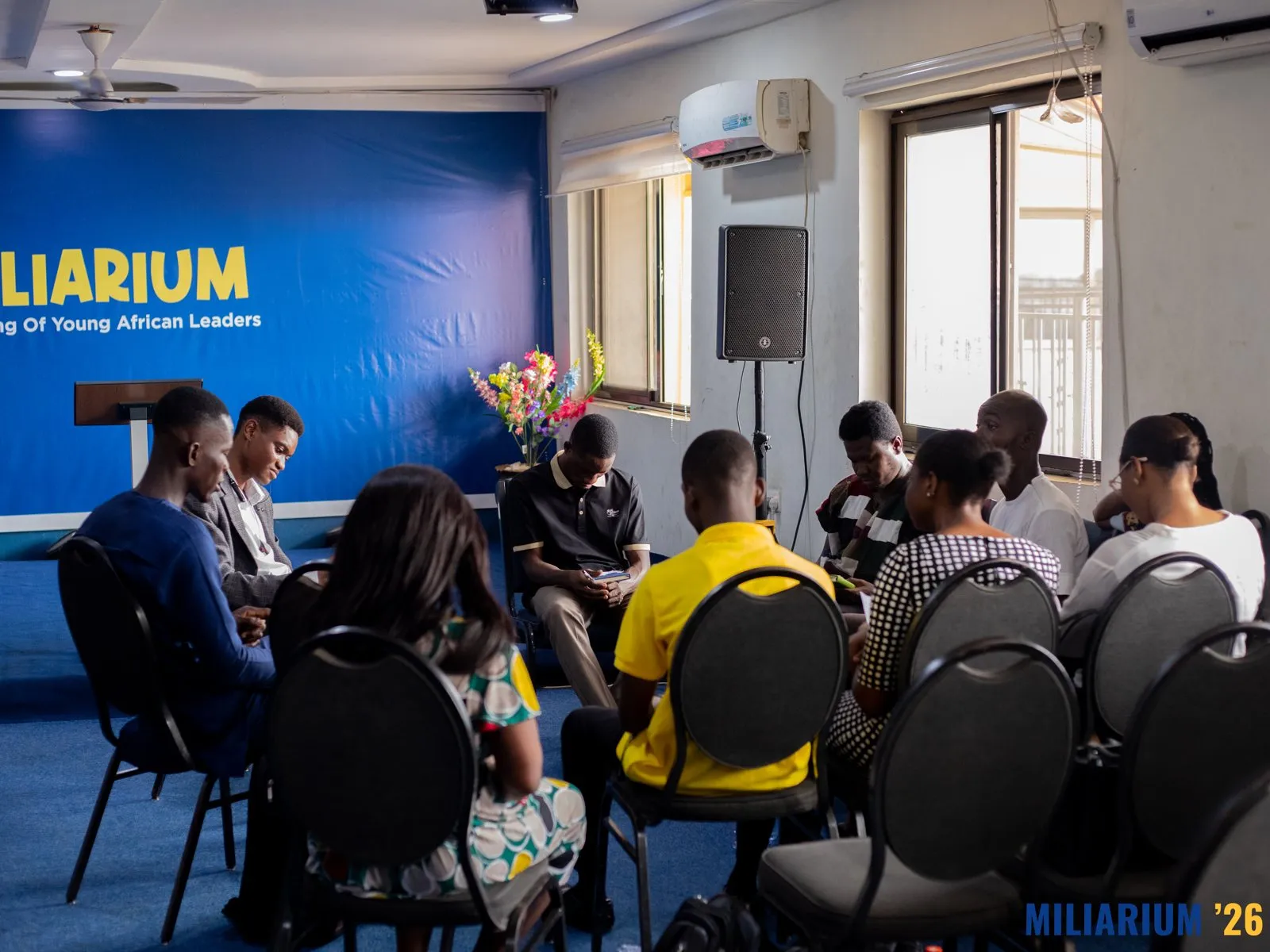 Participants seated in the main hall at The GracedLife Leadership Centre, facing the blue Miliarium banner